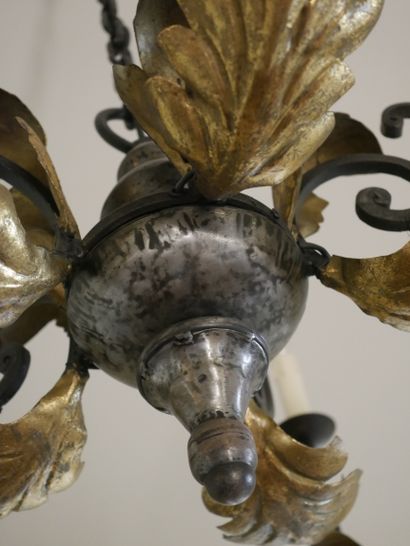 null Lustre en fer forgé doré à cinq bras de lumière à décor de volutes et de feuilles...