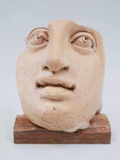 null Female face. Terracotta. Greek style. Restoration to the right eye. H :6cm