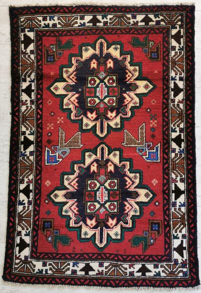 null IRAN. Woolen balouch carpet decorated with two blue medallions on a red background...