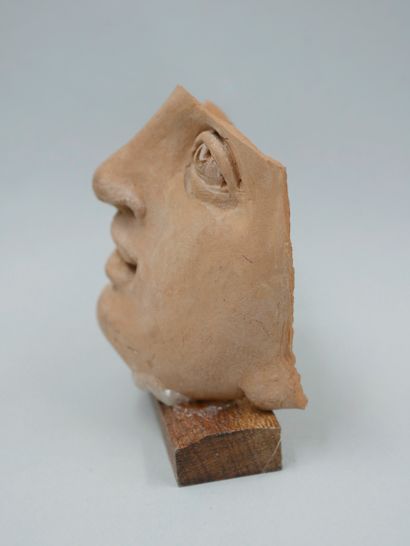 null Female face. Terracotta. Greek style. Restoration to the right eye. H :6cm