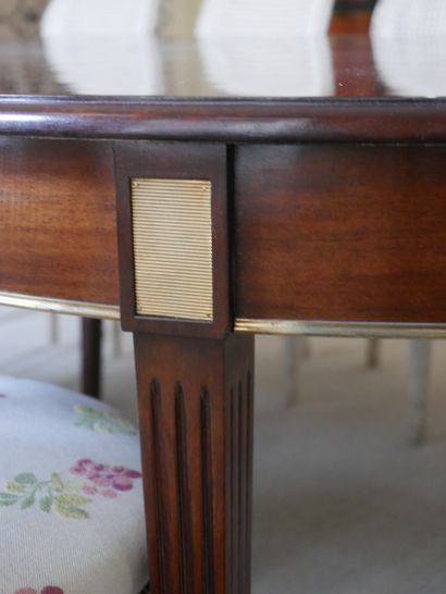 null A large mahogany and mahogany veneer dining room table with fluted legs and...