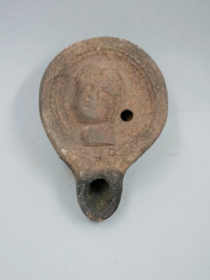 null Oil lamp. Terracotta. Head of a deity. Roman period. L :7,5cm