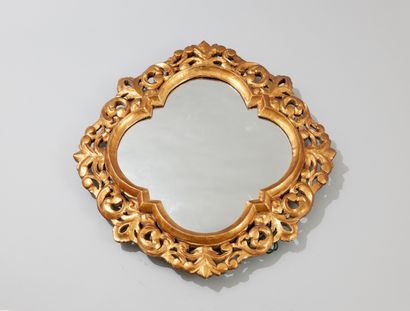 null Miroir en bois sculpté et doré de forme chantournée à décor de volutes et de...