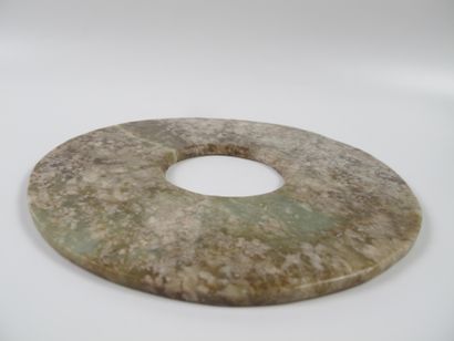 null Jade disc, symbol of Heaven. Celadon nephrite marbled with beige. D 16.5cm....