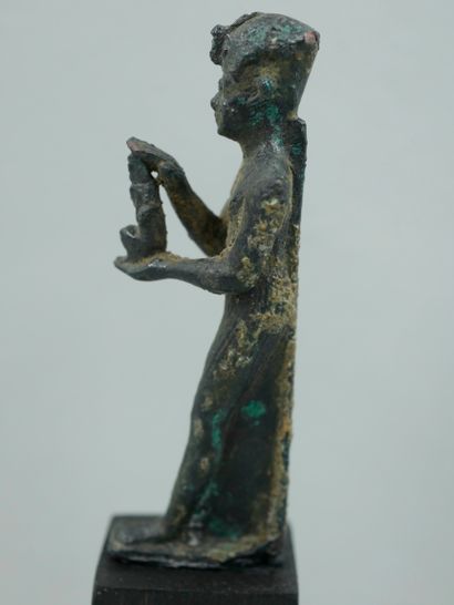 null Pharaoh in devotion, a statuette of the goddess Maat in his hands. Bronze or...