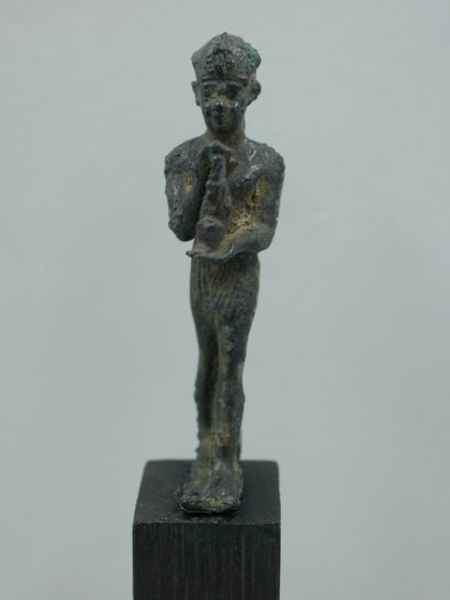 null Pharaoh in devotion, a statuette of the goddess Maat in his hands. Bronze or...