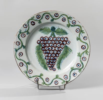 null DELFT. Two circular earthenware dishes, one decorated with a bunch of grapes...
