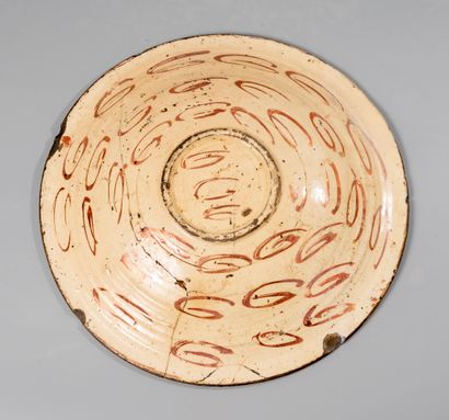 null Lustrous earthenware dish decorated with a bird on a background of foliage....