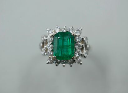 null An 18k white gold ring set with a 1.50ct emerald in a square bezel and surrounded...