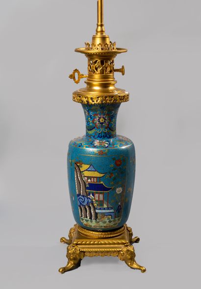 null A bronze and polychrome cloisonné lamp decorated with pagodas and characters...