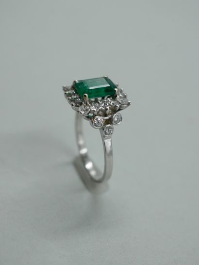 null An 18k white gold ring set with a 1.50ct emerald in a square bezel and surrounded...
