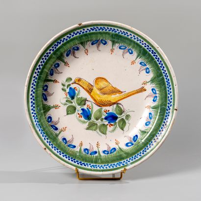 null White earthenware dish decorated with a bird in dominant blue and green surrounded...