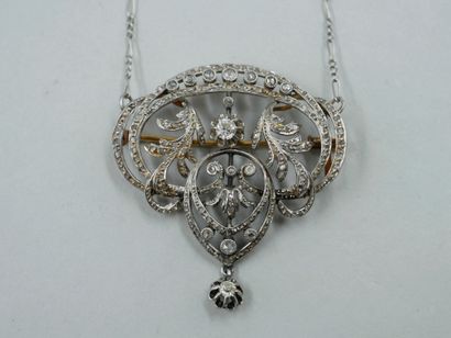 null An 18k gold and silver pendant/brooch with an openwork scroll pattern paved...