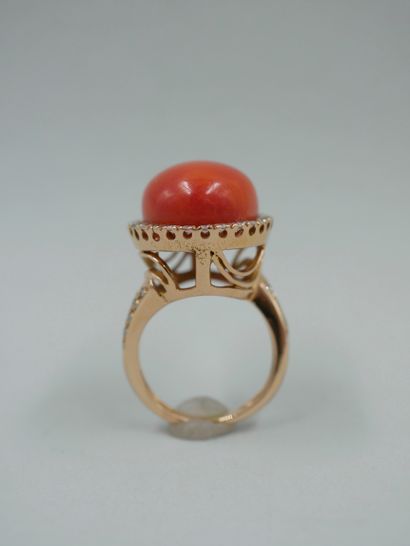 null 18k pink gold ring set with a large coral cabochon surrounded by a line of diamonds...