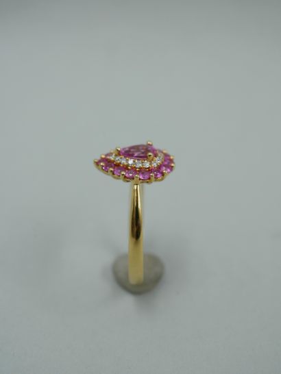 null 18K yellow gold drop ring set in its center with a pear cut pink sapphire in...