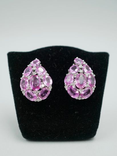 null A pair of 14k white gold drop earrings set with oval pink sapphires, one of...