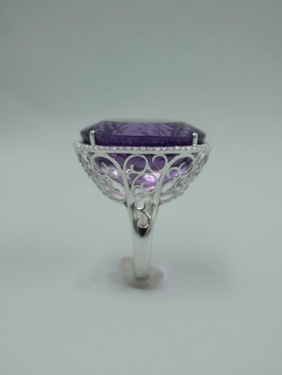 null 18K white gold ring set with a 30cts oval amethyst surrounded by a line of brilliant-cut...