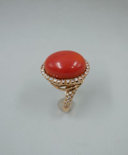 null 18k pink gold ring set with a large coral cabochon surrounded by a line of diamonds...