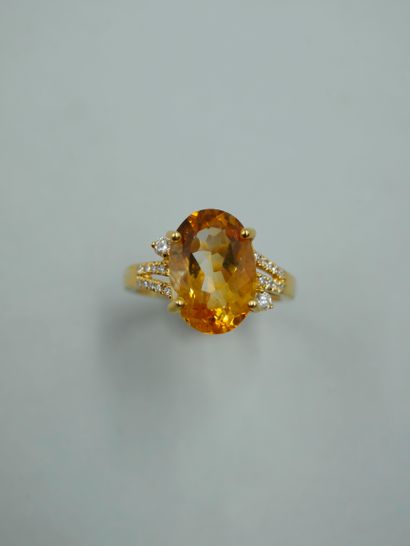 null 18K yellow gold ring set with an oval citrine and two brilliants, with an openwork...