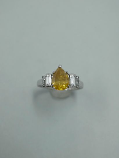 null An 18K white gold ring set with a 2ct fancy yellow pear cut diamond and navette...