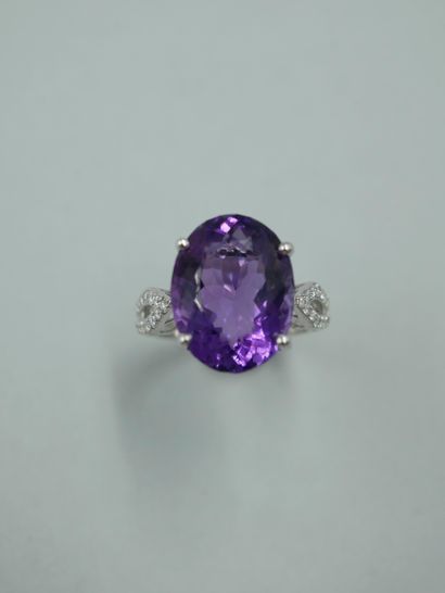 null 18K white gold ring set with an oval amethyst of 10cts and an openwork design...