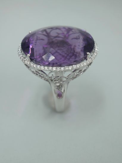null 18K white gold ring set with a 30cts oval amethyst surrounded by a line of brilliant-cut...