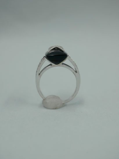 null MAUBOUSSIN. 18K white gold ring set with a cabochon of onyx centered with a...