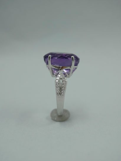 null 18K white gold ring set with an oval amethyst of 10cts and an openwork design...