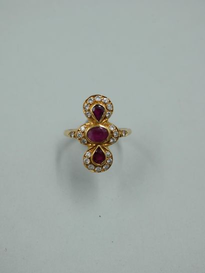 null An 18K yellow gold ring set with three oval and pear-shaped rubies in a setting...