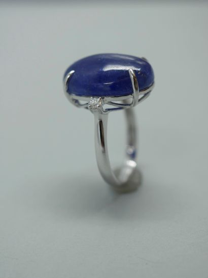 null 18K white gold ring set with an oval cabochon of tanzanite with two brilliant...