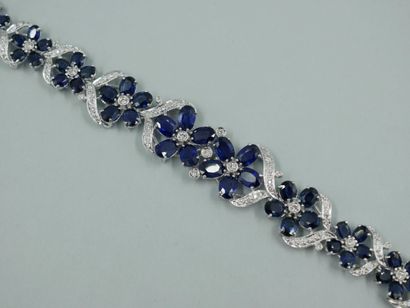 null 18K white gold bracelet with flowers, the petals stylized by oval sapphires...