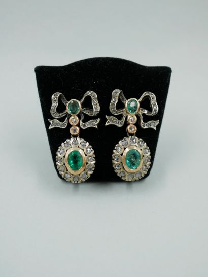 null 
A pair of 14k yellow gold and silver earrings with a bow motif, set with emeralds...