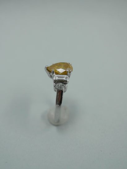 null An 18K white gold ring set with a 2ct fancy yellow pear cut diamond and navette...