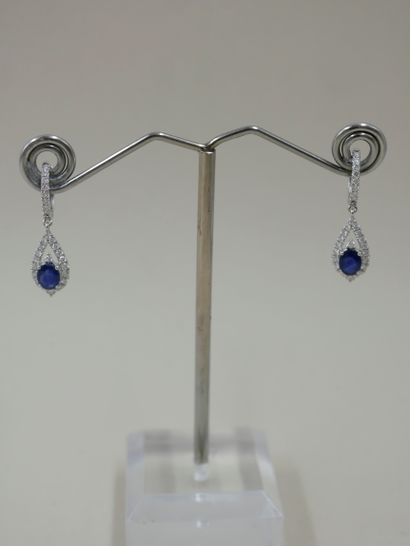 null Pair of 18k white gold earrings holding a pear-shaped diamond-paved motif set...