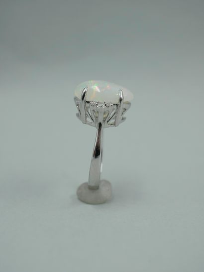 null An 18k white gold ring set with a 4ct opal cabochon and diamonds. TDD : 53....