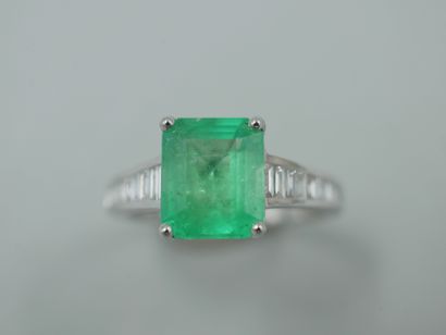 null An 18k white gold ring set with a 2.40cts emerald cut emerald and baguette cut...