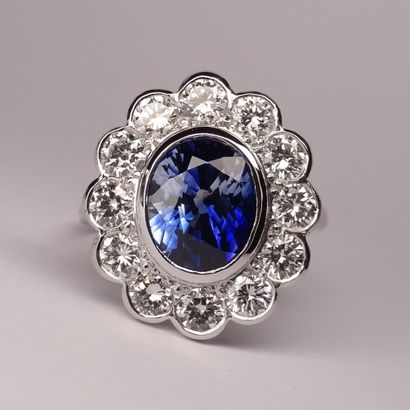 null An 18K white gold Pompadour ring set with a beautiful oval sapphire of about...