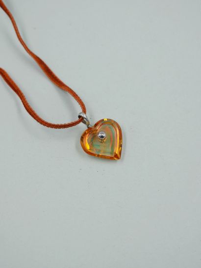 null BACCARAT. Pendant heart of transparent orange color, the silver strap. Engraved...