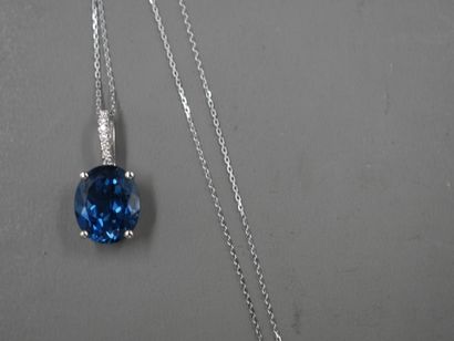 null 18k white gold pendant set with an oval "London Blue" topaz of about 6cts. Diamond-paved...