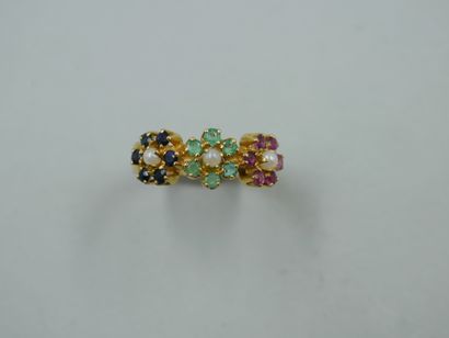 null An 18k yellow gold ring set with three flowers, the petals made of rubies, emeralds...