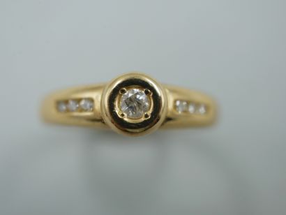 null An 18k yellow gold ring centered on a brilliant-cut diamond in a closed setting,...