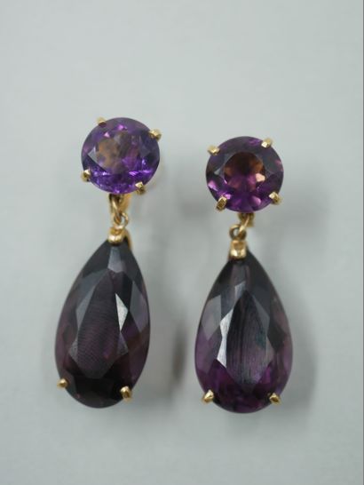 null A pair of 18k yellow gold clip earrings each set with two amethysts, one round...