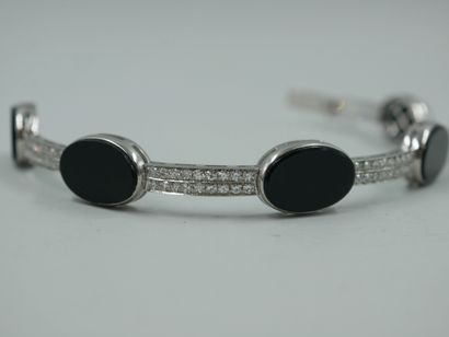 null 
Semi-rigid bracelet in 18k white gold decorated with oval onyx plates alternated...