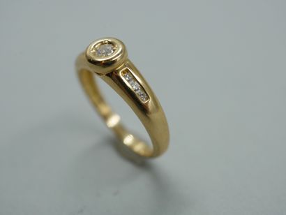 null An 18k yellow gold ring centered on a brilliant-cut diamond in a closed setting,...