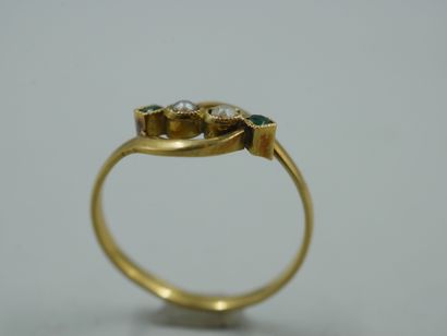 null An 18k yellow gold openwork ring set with pearls and two emeralds. Work of the...