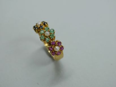 null An 18k yellow gold ring set with three flowers, the petals made of rubies, emeralds...