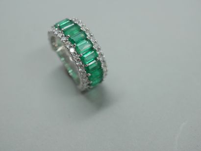null 18k white gold band ring set with a line of emerald cut emeralds for 3cts surrounded...