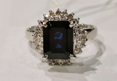 A platinum ring set with an emerald-cut sapphire...