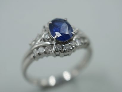 null Platinum ring with a triangular pattern set with a sapphire in a diamond setting....