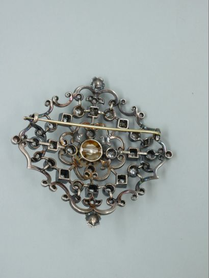 null A 14k white gold and silver brooch with an openwork design, the center set with...